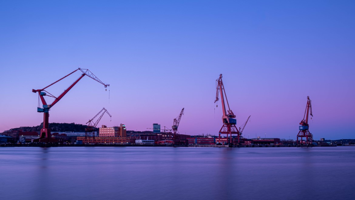 Landscape view of heavy equipment cranes in operation on a waterfront 