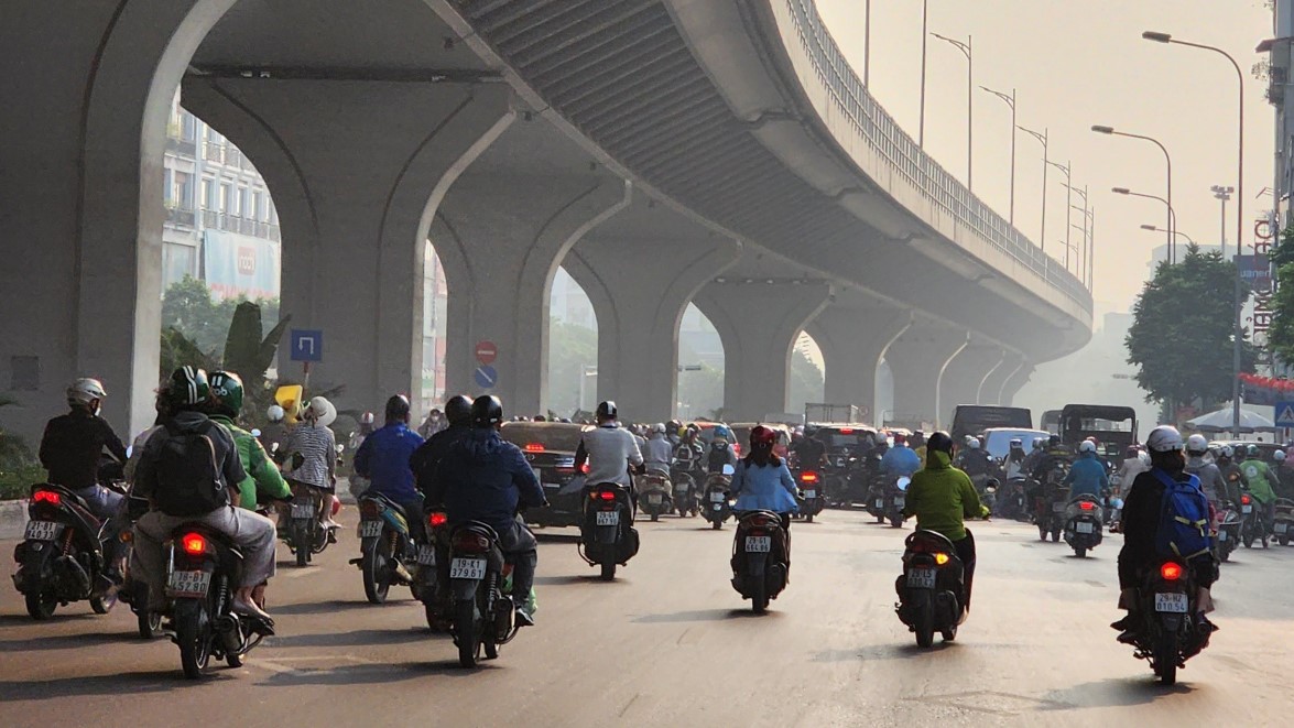 Urban view of large group of motorocycle riders and other vehicles under an overpass