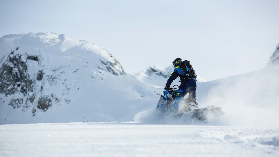 Winter scene with rider on snowmobile in motion through a snowy area