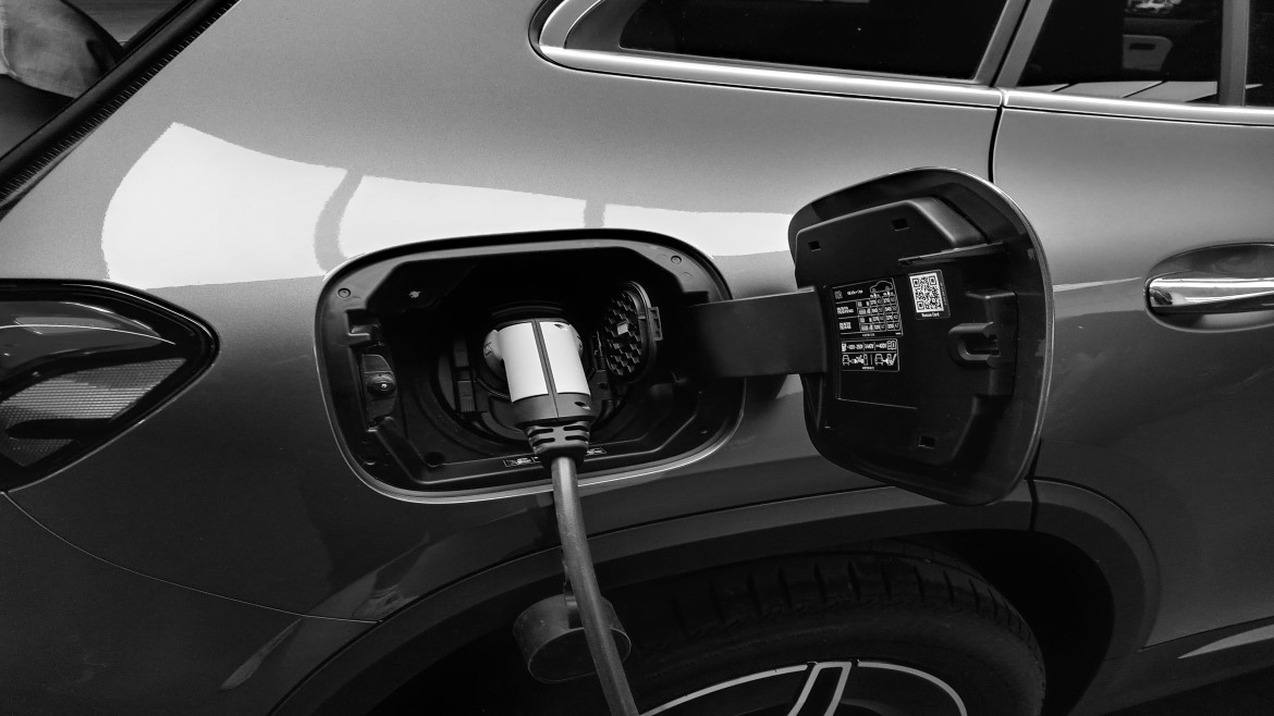 close view of the side of an electric car with the charger in the port