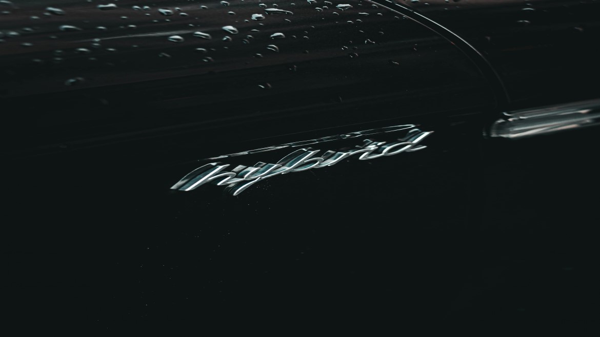 silver script spelling of hybrid on a black background with water drops at the top