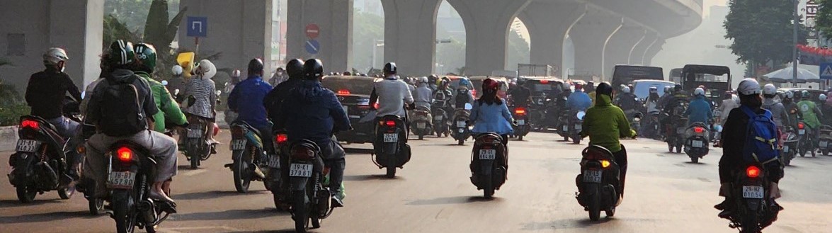 Urban scene of large group of motorcycle riders and other vehicles near a highway overpass
