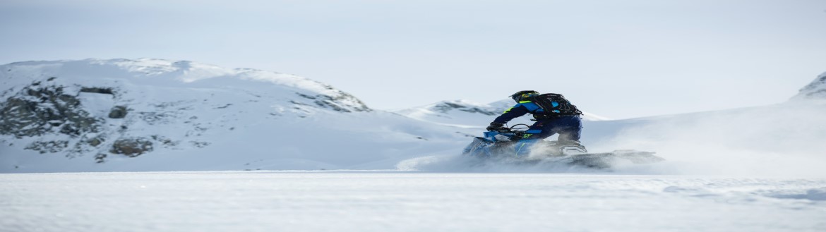 Winter scene with rider on snowmobile in motion through a snowy area