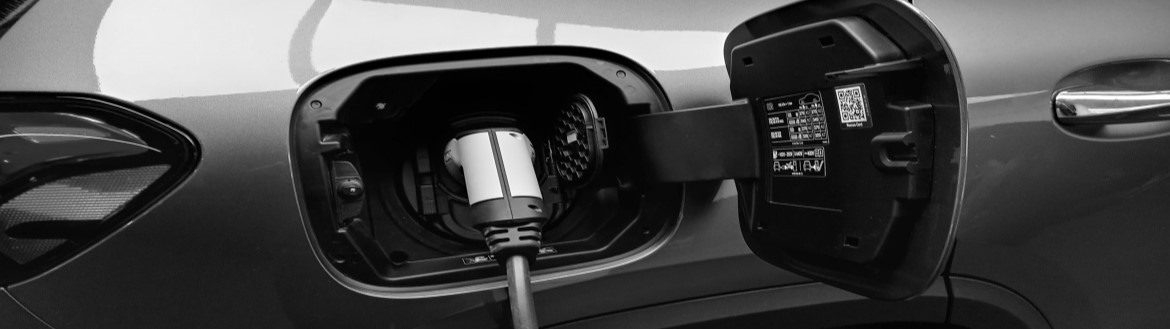 close view of an EV vehicle charger port with charger plugged in