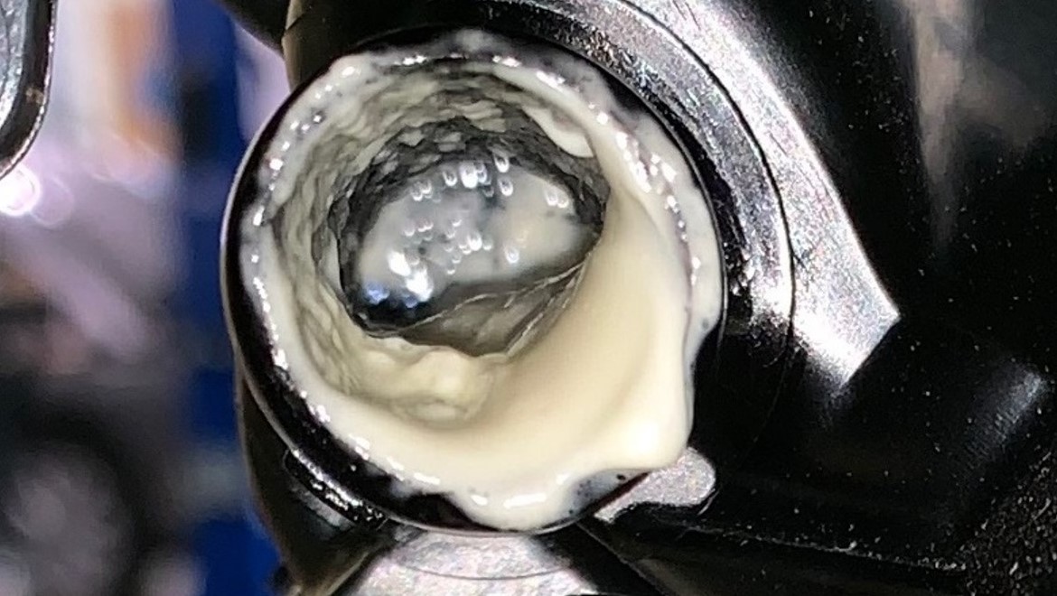 Engine oil emulsification, known as white sludge, appears in this vehicle component as a thick, off-white substance