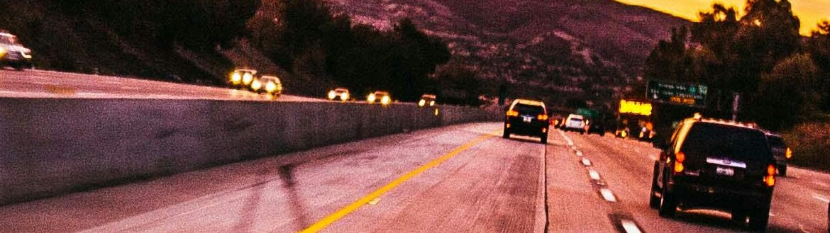 Cars on highway with pink and yellow sky